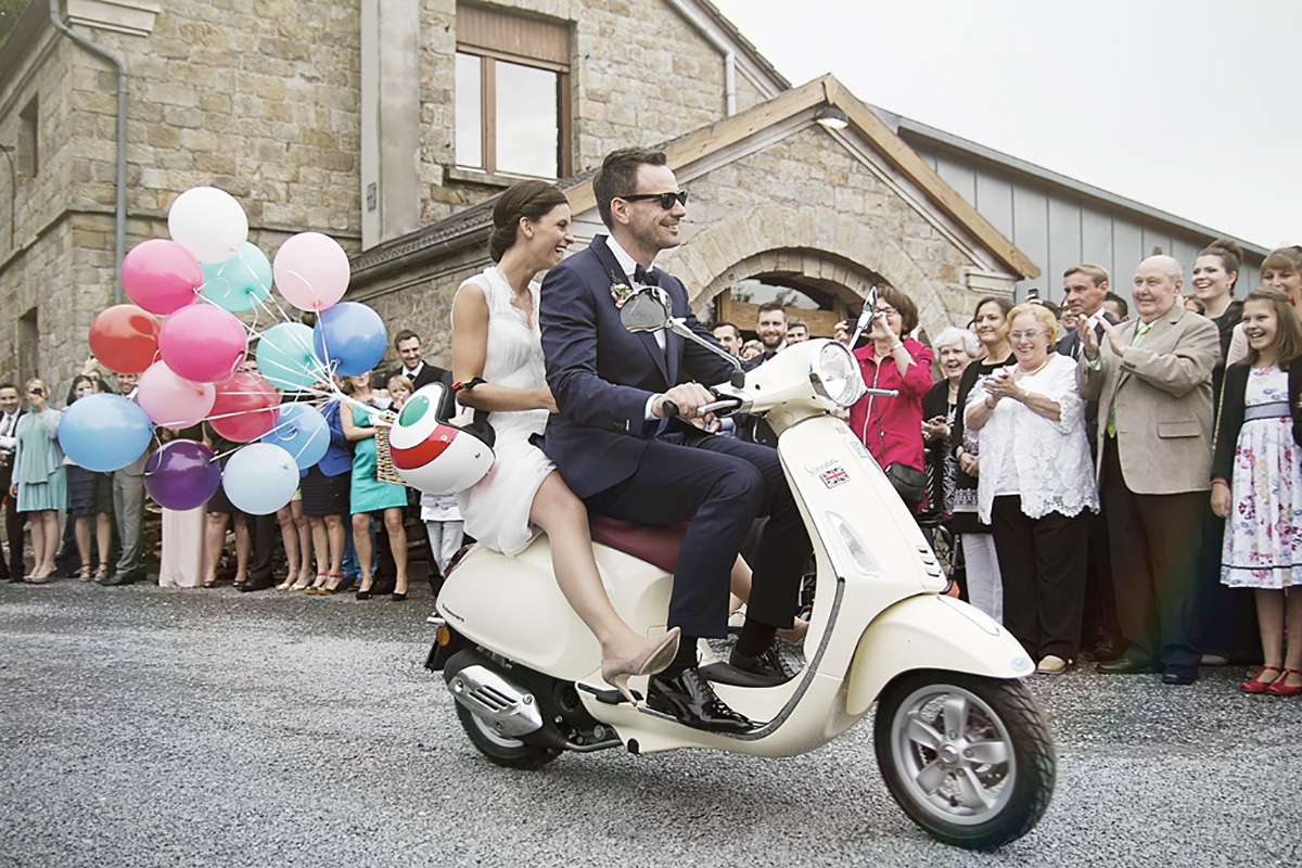 Hochzeitsfotografie Brautpaar auf einem Motorroller zur Location