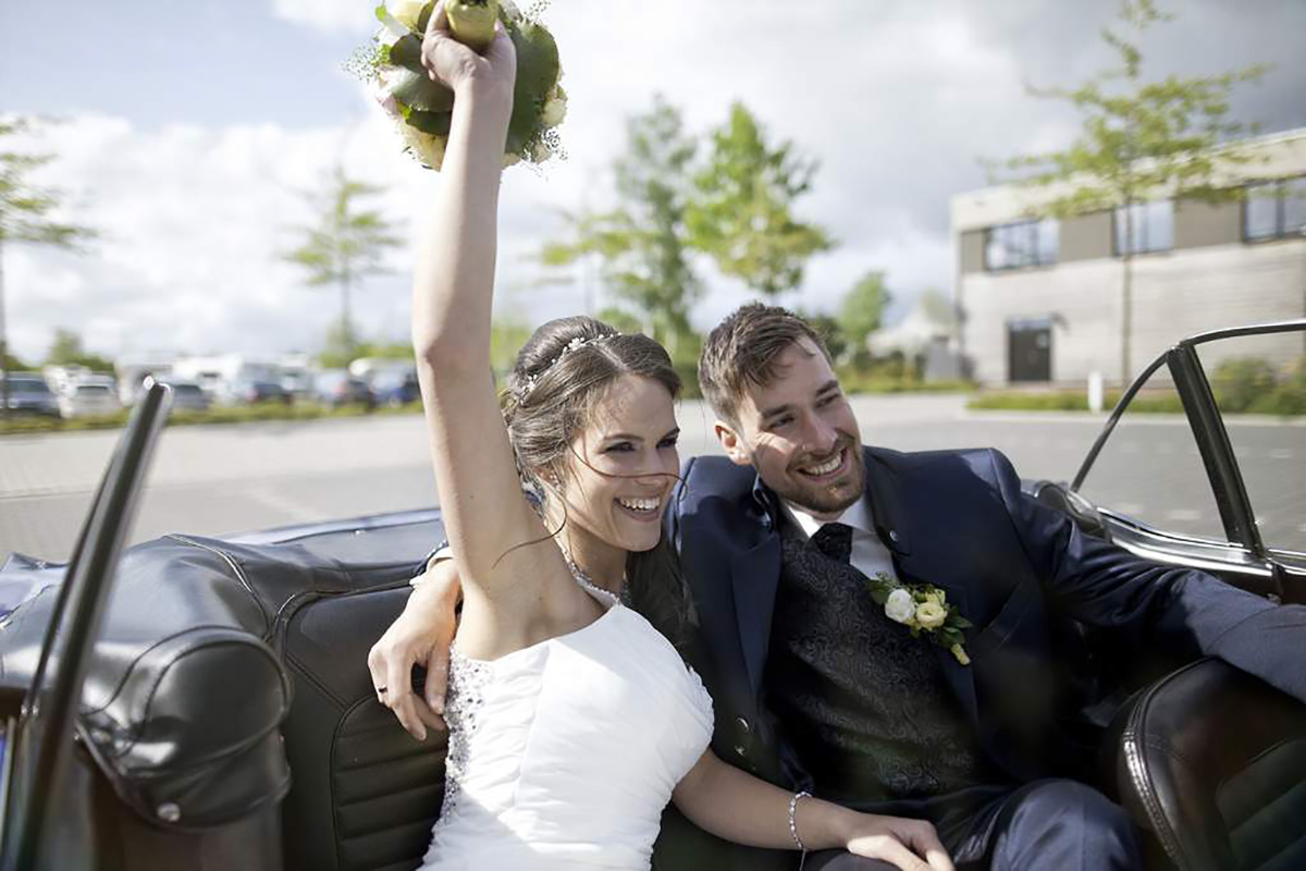 Hochzeitsfotografie Brautpaar auf der Rückbank eines Cabriolets