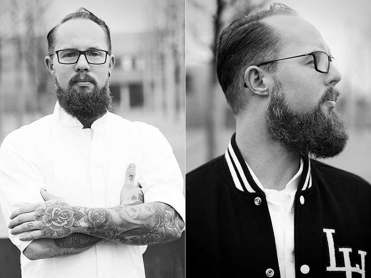 Outdoorfotografie männliche Person mit Tattowierungen, Seitenscheitel, langen Bart und Brille.