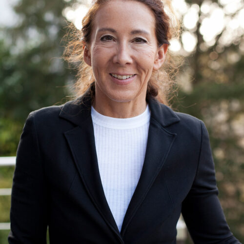 Corporate Portrait: Erfahrene Geschäftsfrau in schwarzer Business-Kleidung im Freien.