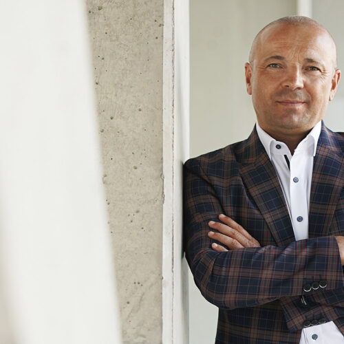 Manager-Portrait: Geschäftsmann im karierten Sakko blickt seriös in die Kamera.