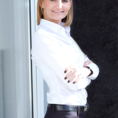 Business-Shooting: Frau in eleganter Kleidung posiert mit verschränkten Armen.