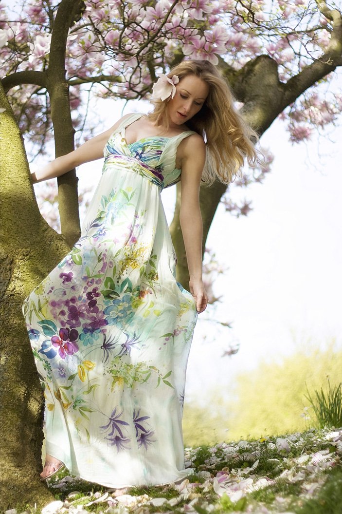 Werbefotografie weibliche Person mit blonden Haaren. Sie trägt ein langes Kleid mit Blüten.