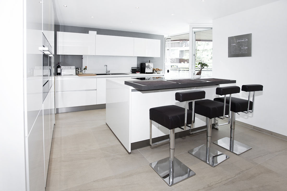 Architekturfotografie weisse Küche mit Holzboden und weißen Möbeln.