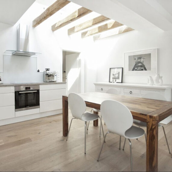 Architekturfotografie weisse Küche mit Holzboden und weissen Möbeln.