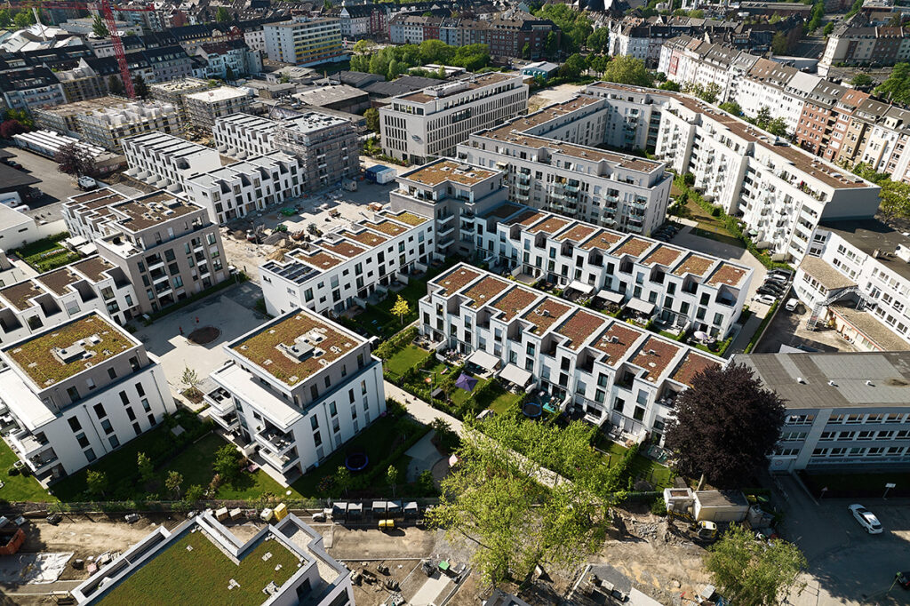 Drohnenfotografie Architektur: Luftaufnahme eines modernen, neu erbauten Wohnquartiers.
