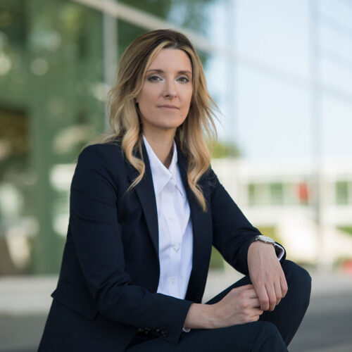 Businessfotografie: Professionelles Porträt einer sitzenden Geschäftsfrau im eleganten schwarzen Blazer.