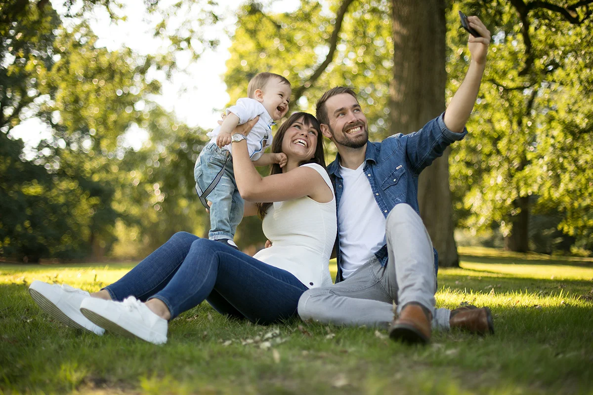 Glückliche Familie mit Baby bei einem natürlichen Familienfotoshooting im Grünen